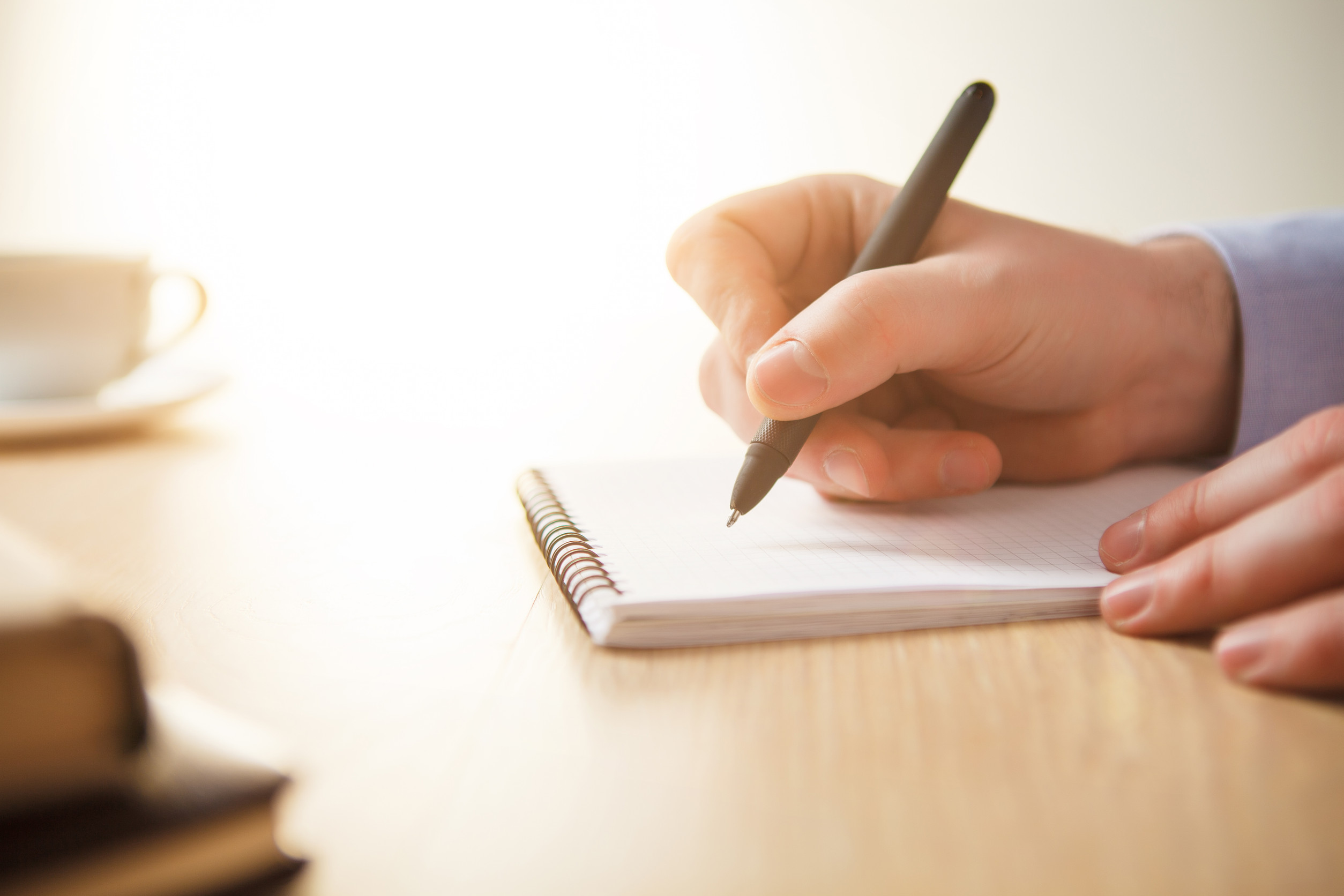 Handwriting in a notebook on a wooden desk